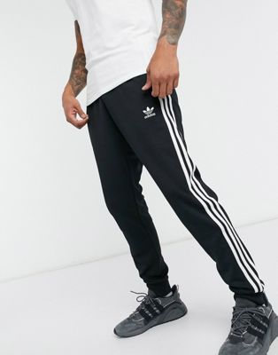 Купить Джоггеры Черные узкие спортивные штаны с тремя полосками adidas Originals adicolor Adidas, цвет - черный, по цене 5 150 рублей в интернет-магазине Usmall.ru