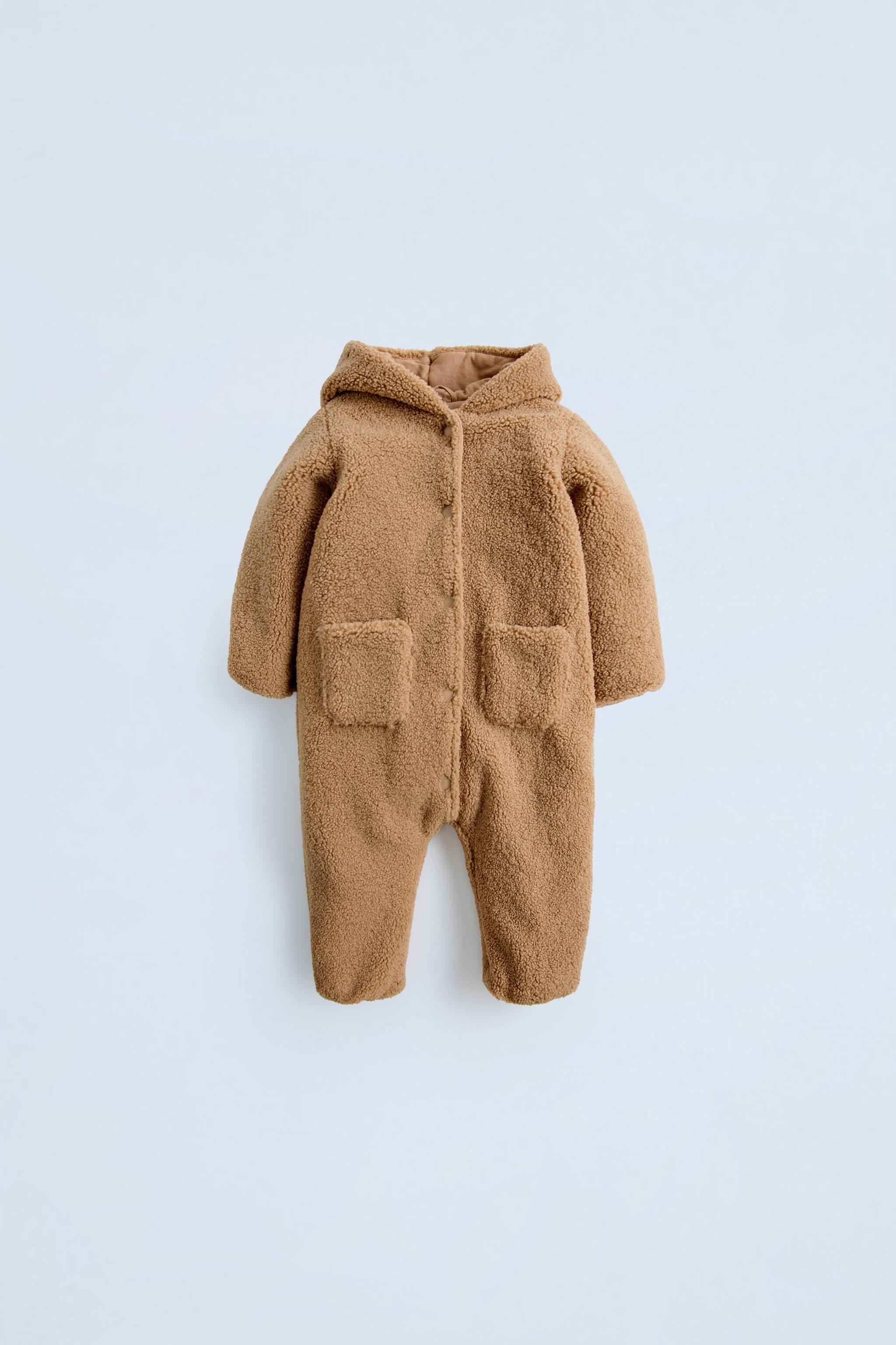 Faux shearling bodysuit with hood and long sleeves. Snap button closure and front patch pockets.Interior lining. ZARA