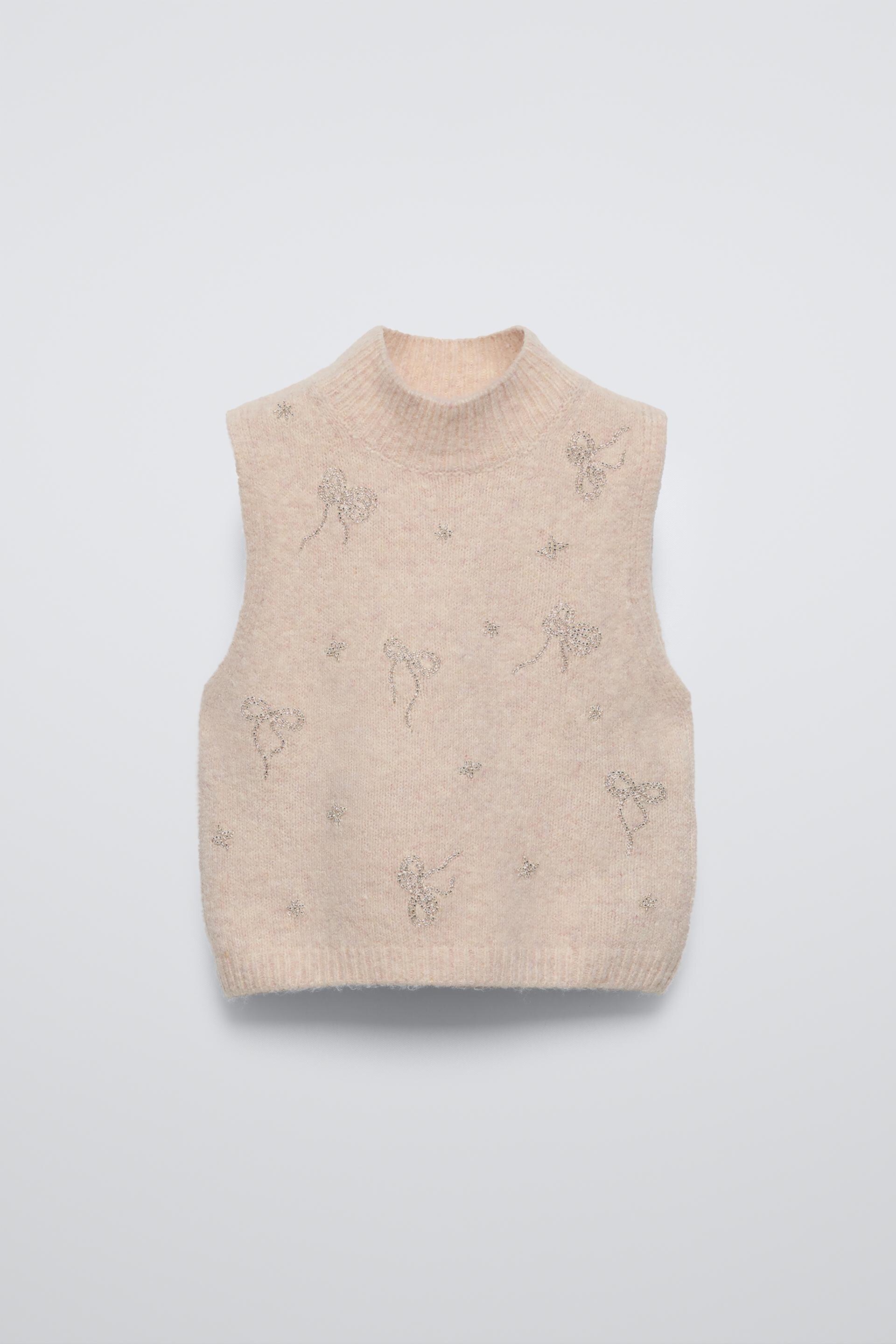 High collar knit vest. Bow shaped beading appliqués at front. ZARA