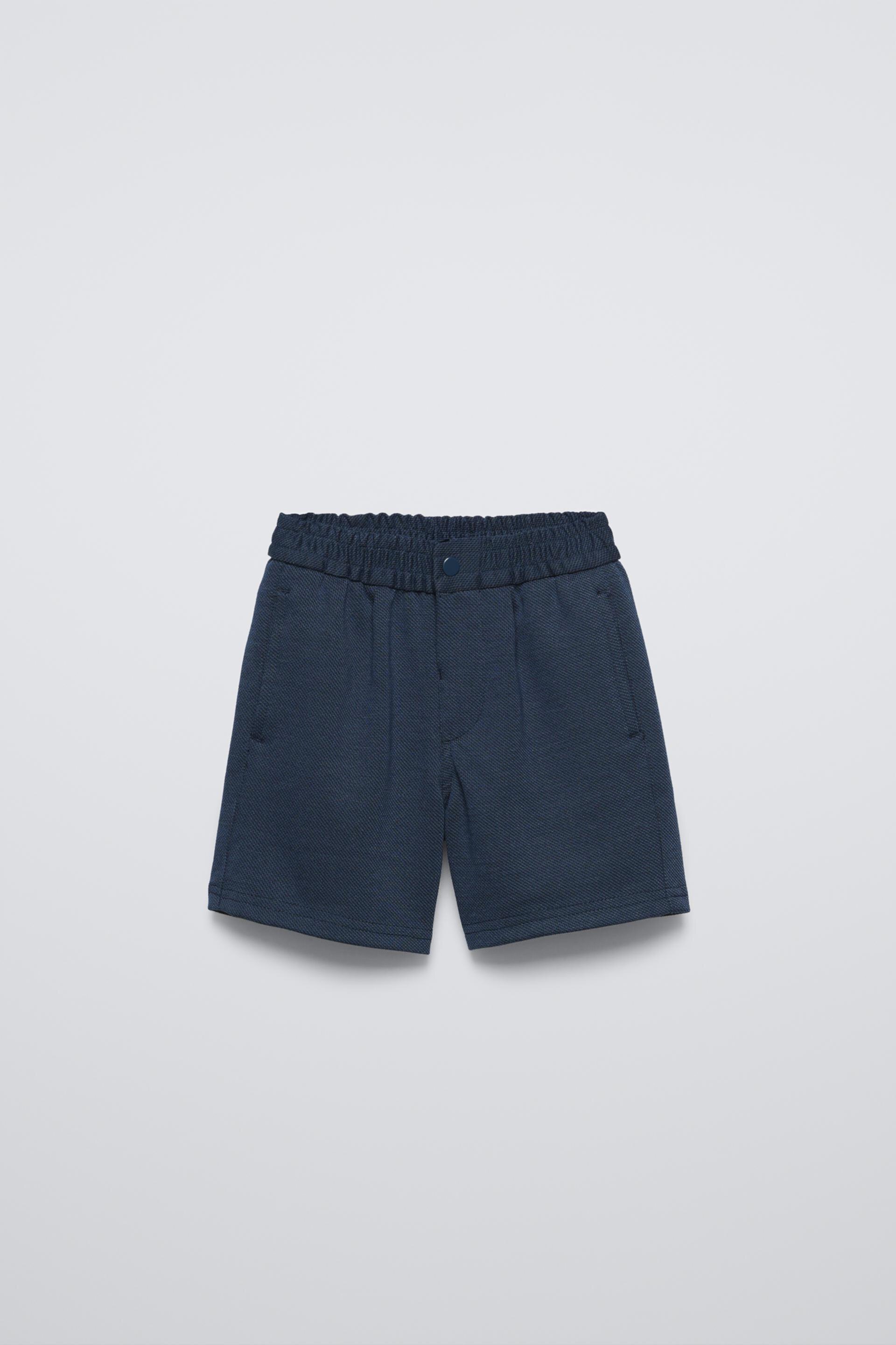 Shorts with elastic waistband and front snap button closure. Front pockets with piping detail and back patch pocket. ZARA