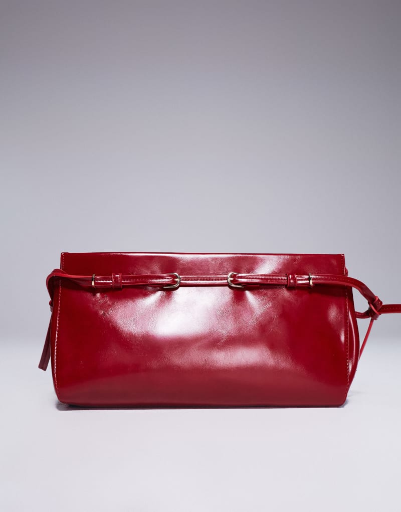 ASOS DESIGN clutch bag with skinny buckle strap detail in red ASOS DESIGN